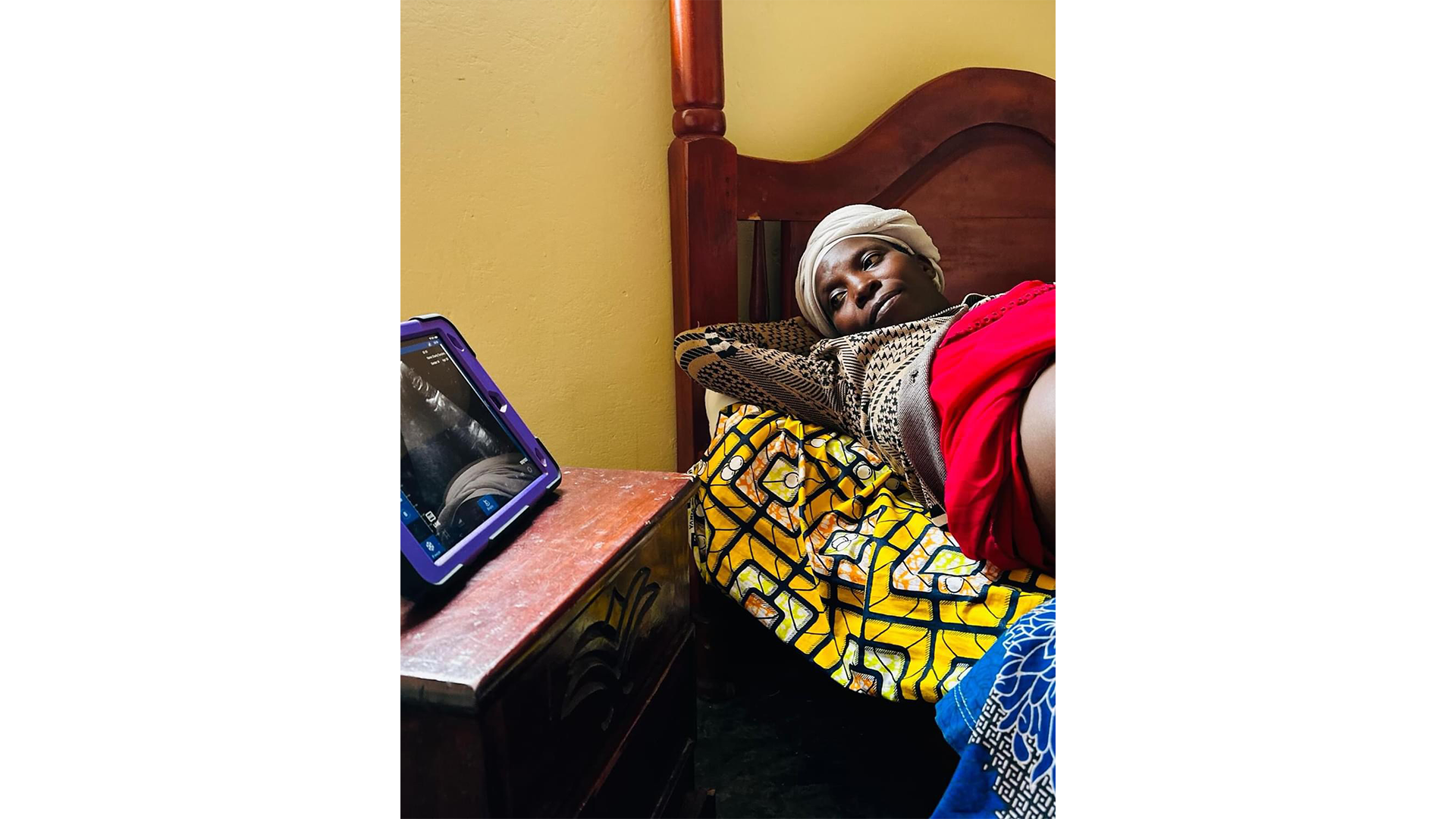 Woman resting on an exam bed during a pregnancy center visit